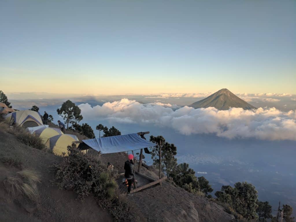 Climbers camping in tents that overlook a large mountain.