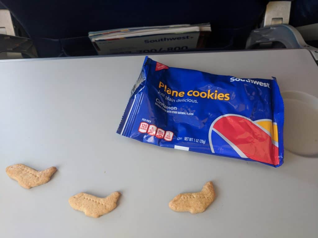 Three plane-shaped Southwest Airlines cookies on the seat back table.